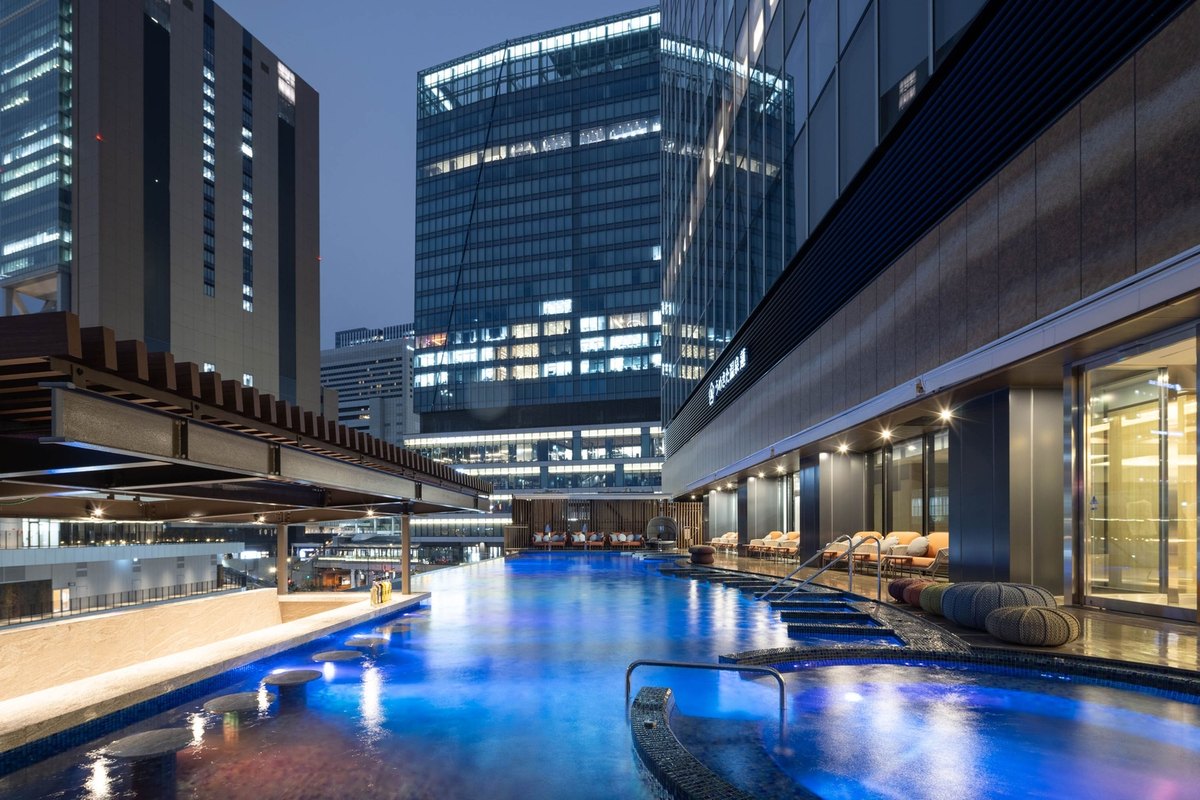 高層ビルを背にした、うめきた温泉 蓮の屋外温水インフィニティプールの夜景